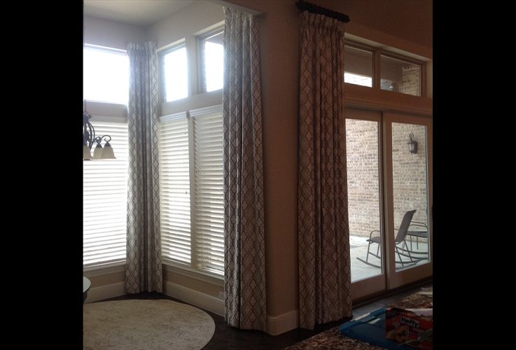 Long curtains and blinds over windows and patio door